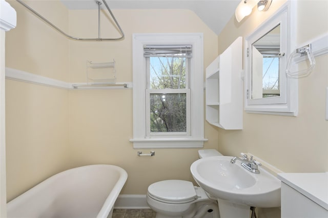 5502 Ingersoll Ave, Des Moines, IA 50312 - bathroom featuring baseboards, toilet, a freestanding tub, and a sink