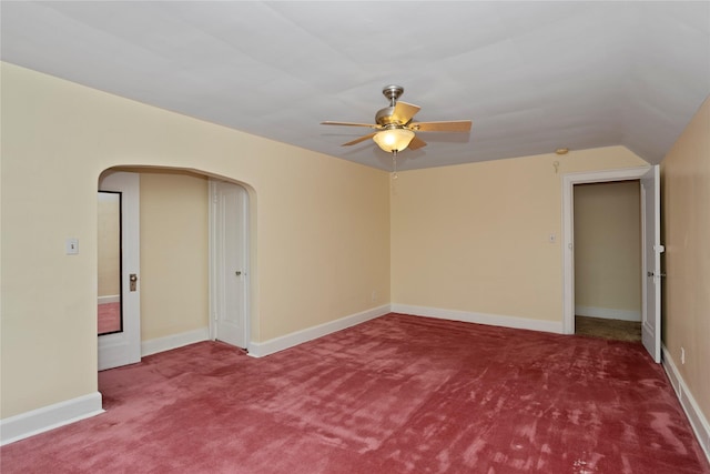 5502 Ingersoll Ave, Des Moines, IA 50312 - spare room featuring lofted ceiling, carpet flooring, baseboards, arched walkways, and a ceiling fan