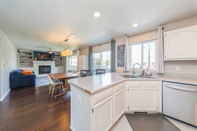 1009 SE 5th St, Grimes, IA 50111 - kitchen with dishwashing machine, a sink, a glass covered fireplace, white cabinets, and recessed lighting