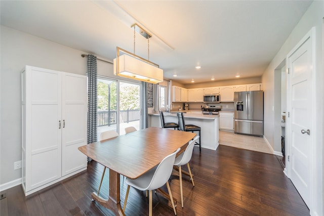 1009 SE 5th St, Grimes, IA 50111 - dining room featuring recessed lighting, wood finished floors, and baseboards
