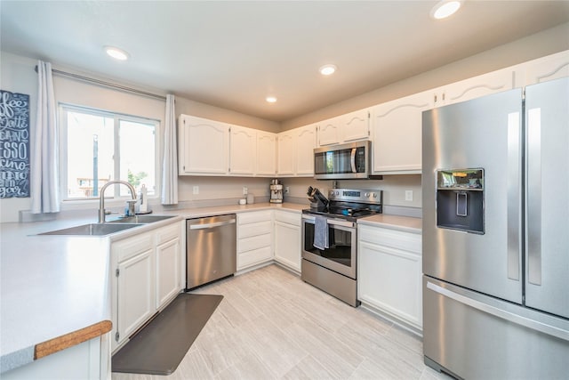 1009 SE 5th St, Grimes, IA 50111 - kitchen with appliances with stainless steel finishes, a sink, white cabinets, light countertops, and recessed lighting