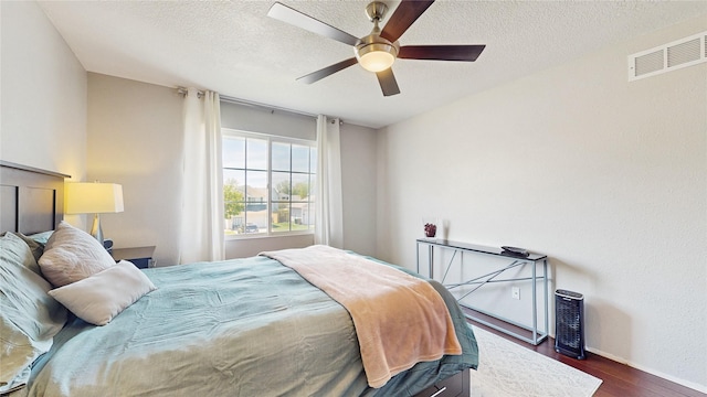 1009 SE 5th St, Grimes, IA 50111 - bedroom featuring dark wood-style floors, baseboards, a textured ceiling, and a ceiling fan