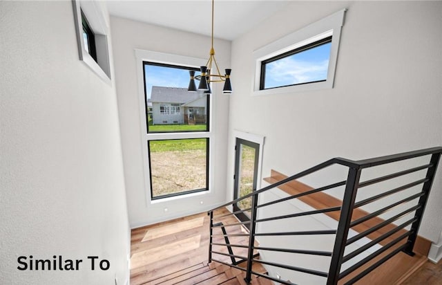 355 NW Red Oak Dr, Waukee, IA 50263 - stairway featuring baseboards, a chandelier, and wood finished floors