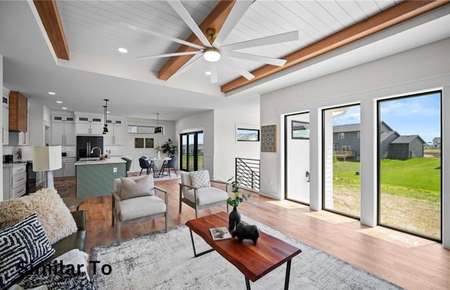 355 NW Red Oak Dr, Waukee, IA 50263 - living area with plenty of natural light, a ceiling fan, light wood finished floors, and beam ceiling