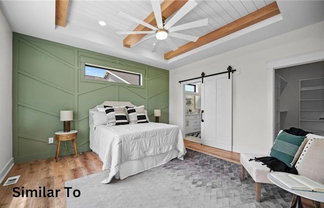355 NW Red Oak Dr, Waukee, IA 50263 - bedroom featuring visible vents, wood finished floors, a barn door, wooden ceiling, and a decorative wall
