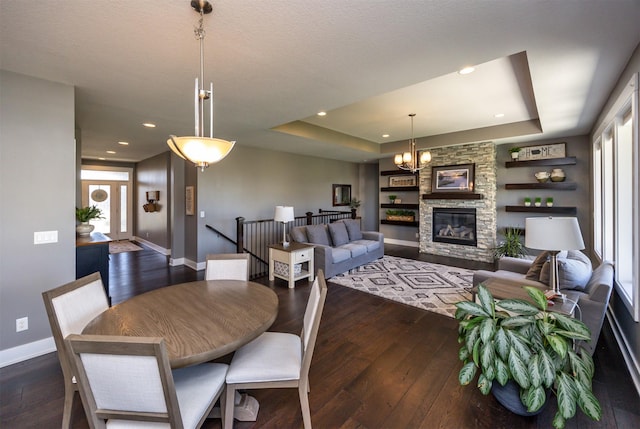 dining room featuring baseboards, plenty of natural light, a tray ceiling, and hardwood / wood-style floors