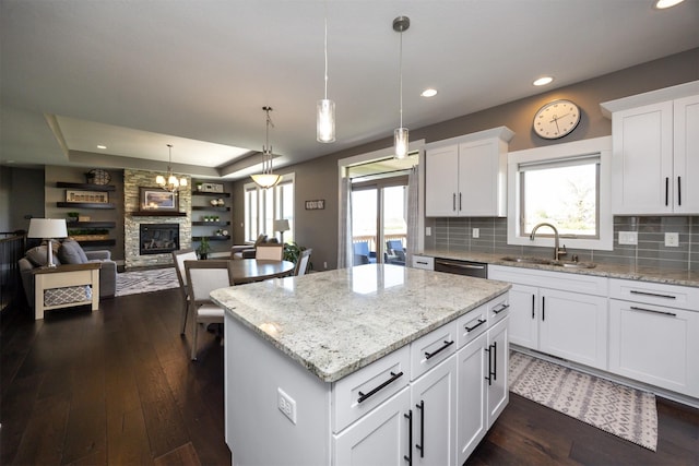 kitchen featuring a kitchen island, dark wood-style flooring, a sink, and tasteful backsplash