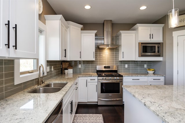 kitchen with a sink, white cabinetry, wall chimney range hood, and stainless steel appliances