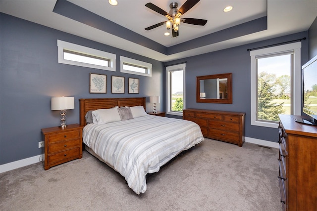 bedroom featuring baseboards, recessed lighting, a raised ceiling, and light carpet