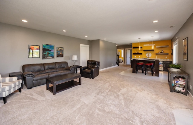 living room featuring light colored carpet, recessed lighting, wet bar, and baseboards