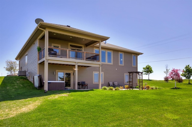rear view of house with a yard, central AC unit, and a balcony
