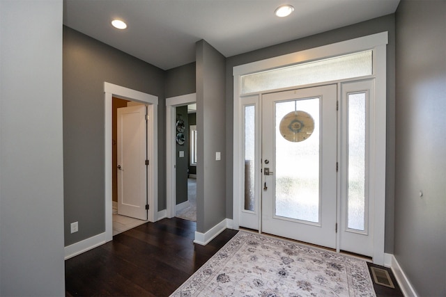 foyer featuring visible vents, recessed lighting, baseboards, and dark wood-type flooring