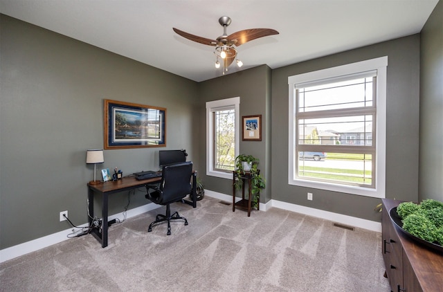 carpeted office space featuring ceiling fan, visible vents, and baseboards