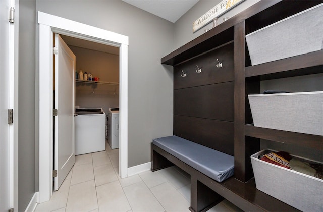 mudroom featuring washer and dryer, baseboards, and light tile patterned floors