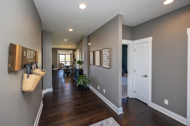 hall featuring wood-type flooring, recessed lighting, and baseboards