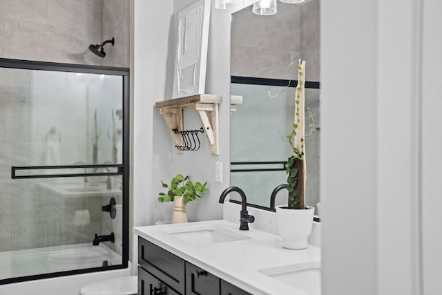 970 Roman Rd, Waukee, IA 50263 - bathroom with double vanity, toilet, combined bath / shower with glass door, and a sink