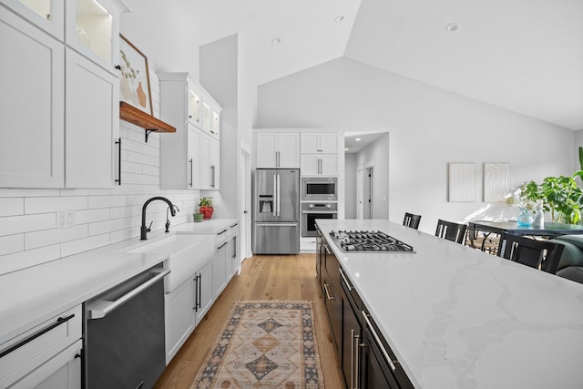 970 Roman Rd, Waukee, IA 50263 - kitchen featuring backsplash, appliances with stainless steel finishes, vaulted ceiling, a sink, and white cabinets