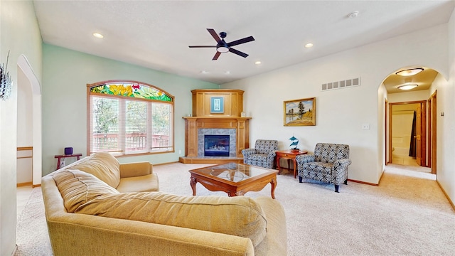 living area with arched walkways, ceiling fan, light colored carpet, and visible vents