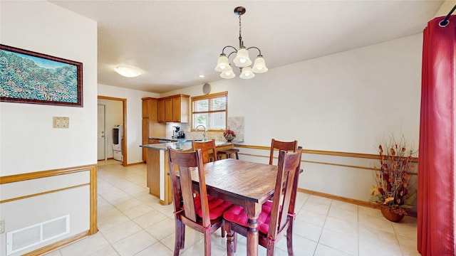dining area featuring visible vents, baseboards, light tile patterned floors, and a notable chandelier