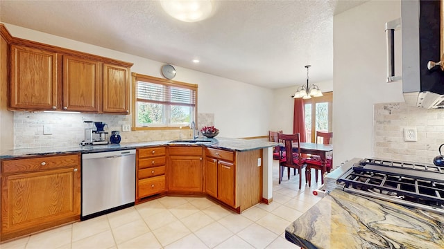 kitchen with a sink, a chandelier, a peninsula, a wealth of natural light, and stainless steel dishwasher