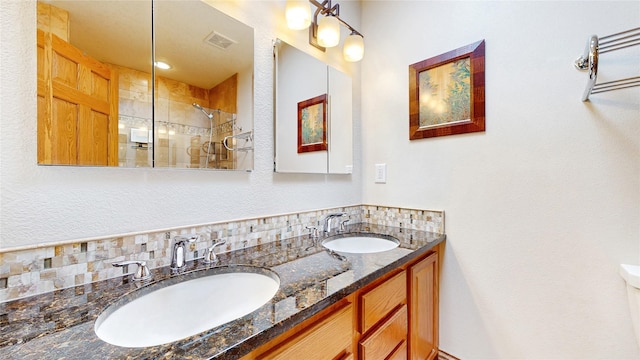 full bathroom with visible vents, a sink, a tile shower, and double vanity