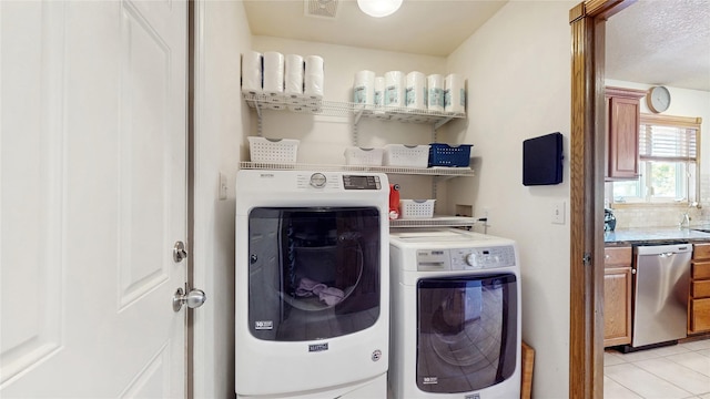 laundry area featuring laundry area, light tile patterned floors, washer and dryer, and visible vents