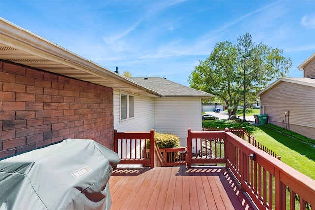 wooden deck featuring area for grilling and a yard