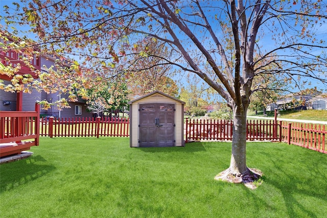 view of yard featuring a storage unit, a fenced backyard, and an outbuilding