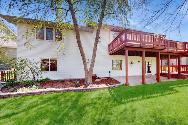 rear view of property with a patio, a yard, and a deck