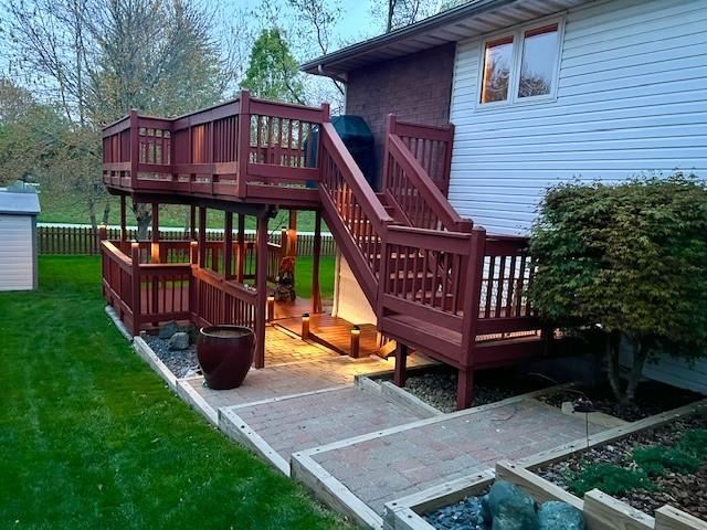 view of play area with a lawn, fence, and a wooden deck