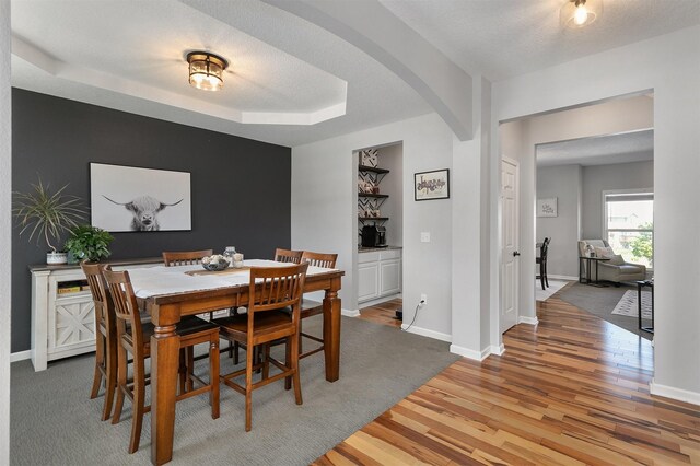 7517 NW 97th Ct, Johnston, IA 50131 - dining room with arched walkways, wood finished floors, baseboards, and a tray ceiling