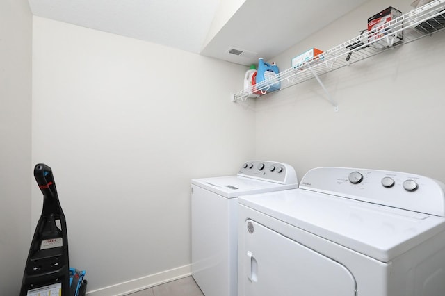 clothes washing area with laundry area, washer and dryer, baseboards, and visible vents
