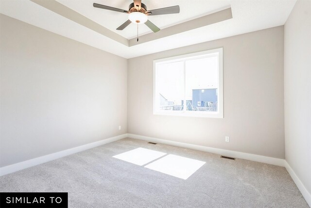 2917 6th Ave SW, Altoona, IA 50009 - carpeted empty room with visible vents, a ceiling fan, baseboards, and a tray ceiling