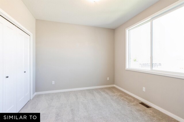 2917 6th Ave SW, Altoona, IA 50009 - unfurnished bedroom featuring baseboards, visible vents, carpet, and a closet