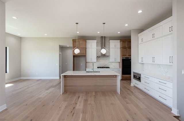 kitchen with recessed lighting, a sink, wall chimney range hood, and tasteful backsplash