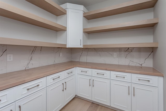 kitchen featuring wood counters, tasteful backsplash, open shelves, and white cabinets