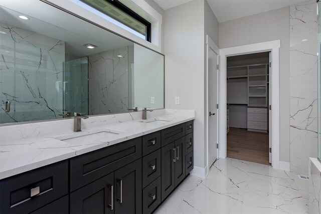 17778 Hammontree Dr, Clive, IA 50325 - full bathroom with double vanity, a marble finish shower, a walk in closet, marble tiled floors, and recessed lighting