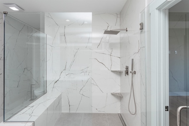 bathroom featuring a marble finish shower