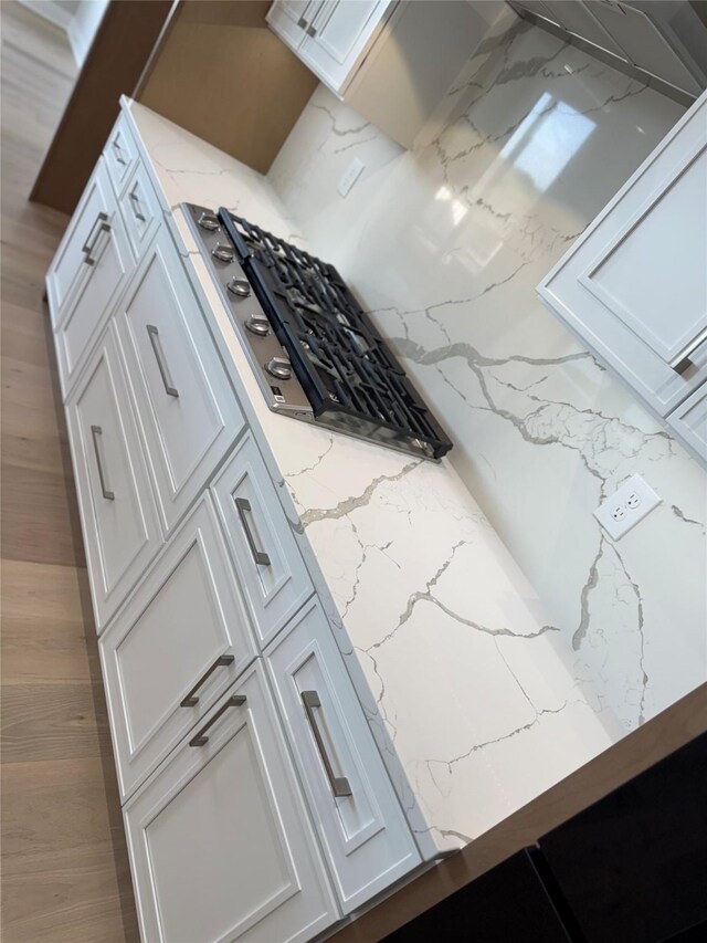 17778 Hammontree Dr, Clive, IA 50325 - kitchen featuring light stone countertops and white cabinetry