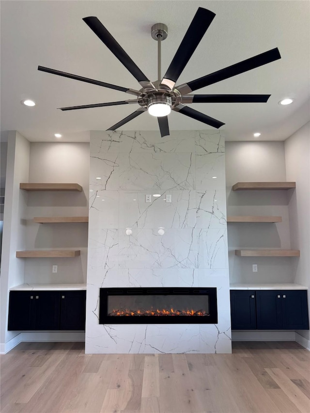 room details featuring ceiling fan, a fireplace, and wood finished floors