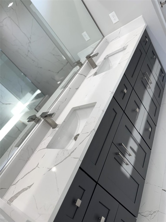 bathroom with double vanity and marble finish floor