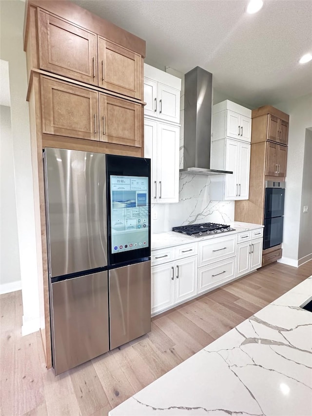 17778 Hammontree Dr, Clive, IA 50325 - kitchen with stainless steel appliances, wall chimney range hood, baseboards, decorative backsplash, and light wood-style flooring