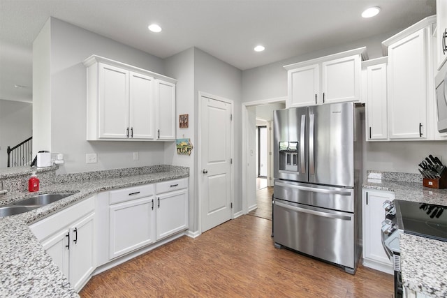 188 Bridgewood Dr, West Des Moines, IA 50266 - kitchen featuring a sink, light wood-style flooring, white cabinetry, and stainless steel appliances
