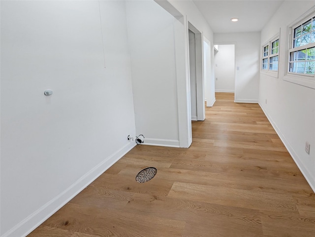 hall with baseboards, recessed lighting, and light wood-style flooring