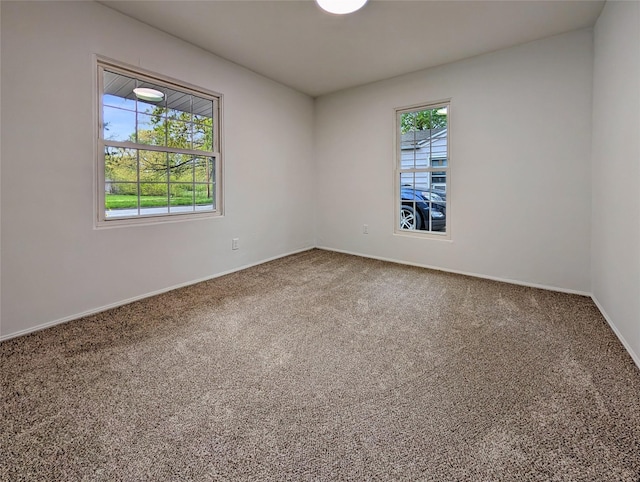 carpeted empty room with baseboards