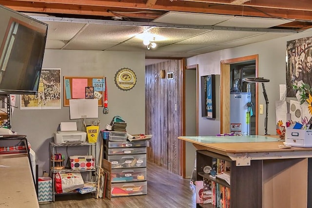 interior space featuring a paneled ceiling, water heater, and wood finished floors