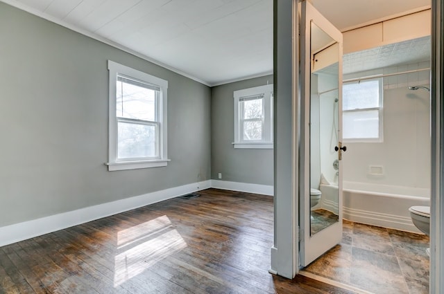 unfurnished bedroom featuring baseboards, ornamental molding, visible vents, and dark wood-type flooring