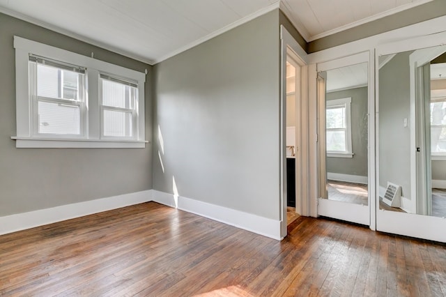 empty room featuring baseboards, ornamental molding, and hardwood / wood-style floors