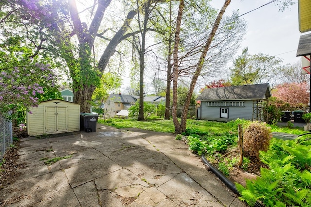 view of patio / terrace with a shed, an outbuilding, and fence