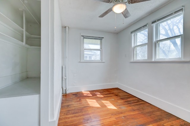 spare room featuring baseboards, a ceiling fan, and hardwood / wood-style floors